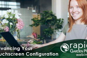 A smiling garden center employee stands behind a counter with flowers, using a touch screen monitor. It is set against a blurred background of a modern, green-themed space. Text: "Advancing Your Touchscreen Configuration" -- A Rapid Garden POS webinar