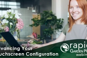 A smiling garden center employee stands behind a counter with flowers, using a touch screen monitor. It is set against a blurred background of a modern, green-themed space. Text: "Advancing Your Touchscreen Configuration" -- A Rapid Garden POS webinar
