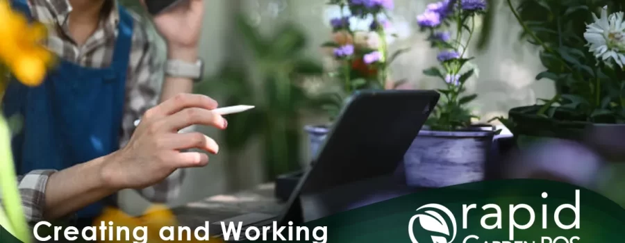 A man uses a tablet to create a sales kit within the robust Rapid Garden POS software in a garden retail setting. He is holding a pen and speaking on a phone while looking at a tablet. Surrounding them are colorful potted plants. Text: "Creating and Working with Sales Kits" -- a Rapid Garden POS webinar