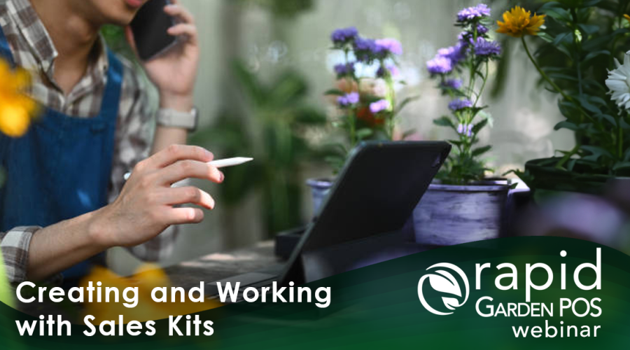 A man uses a tablet to create a sales kit within the robust Rapid Garden POS software in a garden retail setting. He is holding a pen and speaking on a phone while looking at a tablet. Surrounding them are colorful potted plants. Text: "Creating and Working with Sales Kits" -- a Rapid Garden POS webinar