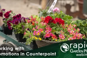 A garden center worker pulls a cart filled with colorful potted flowers and plants. Text: "Working with Promotions in Counterpoint" -- A Rapid Garden POS webinar.