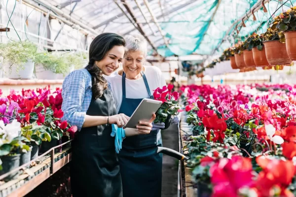 garden center owner and daughter looking at tablet for inventory