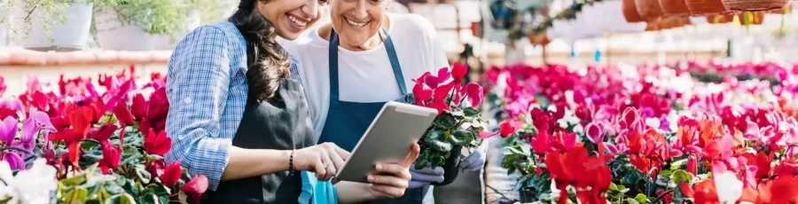 garden center owner and daughter looking at tablet for inventory