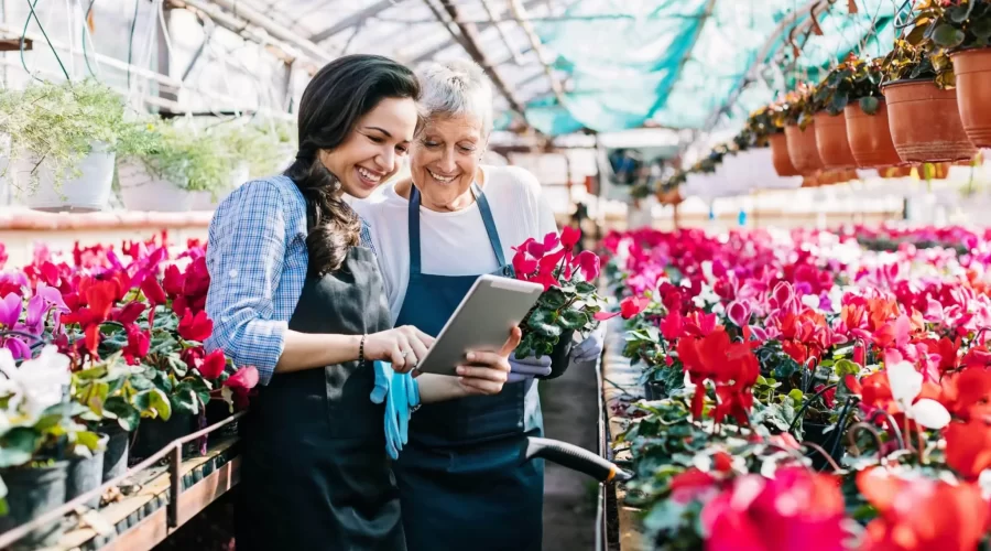 garden center owner and daughter looking at tablet for inventory