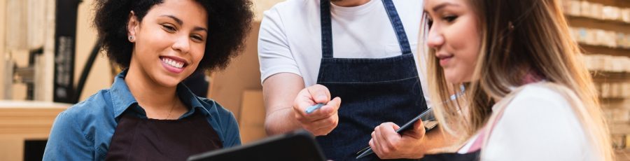 Male employee communicating changes for inventory management on a tablet in a backroom.