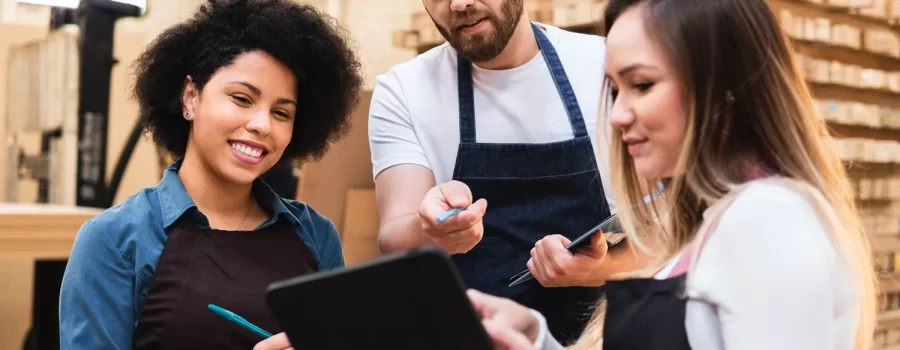 Male employee communicating changes for inventory management on a tablet in a backroom.